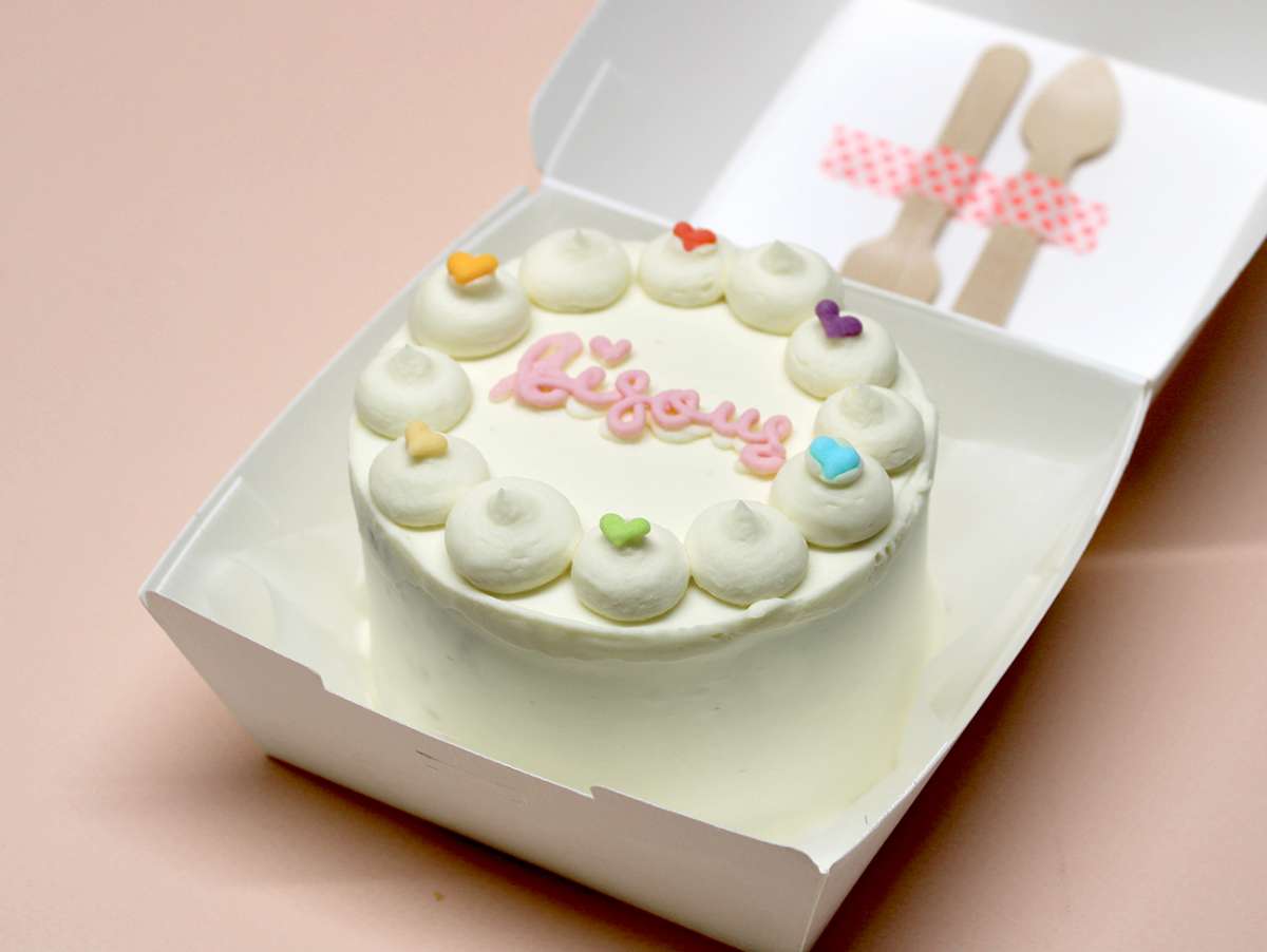 Bento cake Paris "Bisous" de la pâtisserie Chez Bogato, au chocolat blanc et petits coeurs multicolores.